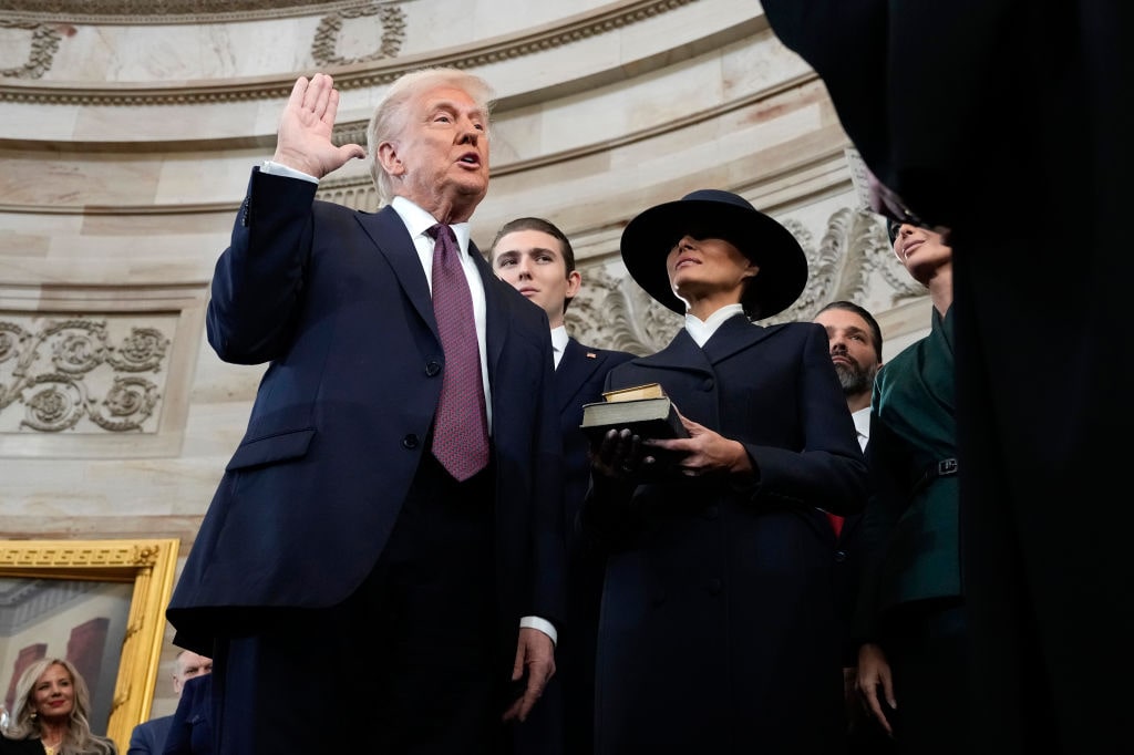 The Inauguration Of Donald J. Trump As The 47th PresidentWASHINGTON, DC - JANUARY 20: U.S. President-elect Donald Trump takes the oath of office from Chief Justice John Roberts as Barron Trump and Melania Trump look on during inauguration ceremonies in the Rotunda of the U.S. Capitol on January 20, 2025 in Washington, DC. Donald Trump takes office for his second term as the 47th President of the United States. (Photo by Morry Gash - Pool/Getty Images)